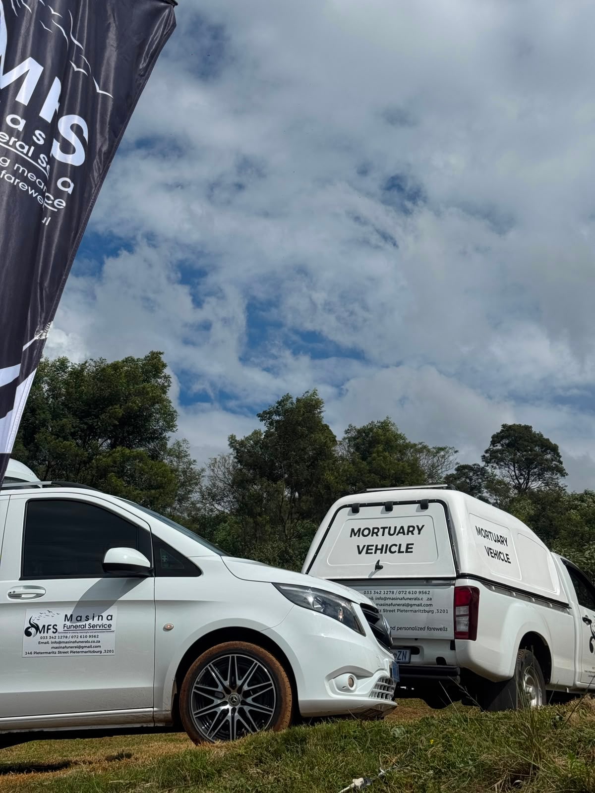 A Masina Funeral Service mortuary vehicle with the branded flag
